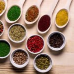 spices in plates and spoons on wooden table